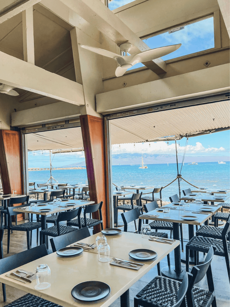 Bright seaside restaurant with ocean views and open-air dining ambiance.