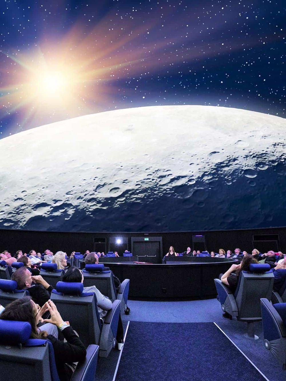Stargazing movie theater experience with a planetarium screen showing the night sky and moon.