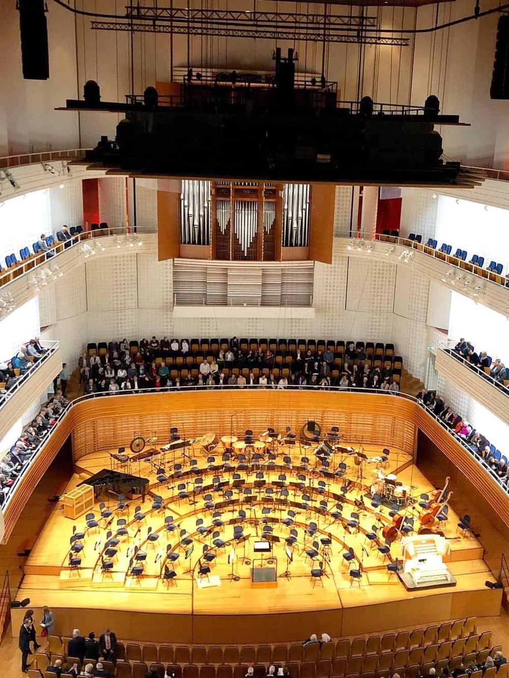 Elegant concert hall interior with orchestra stage, audience seating, and grand piano for live performances.