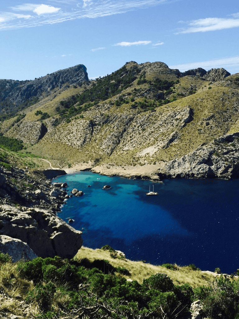 Breathtaking mountain landscape with blue waters and a sailboat, perfect for outdoor adventure and navigation.