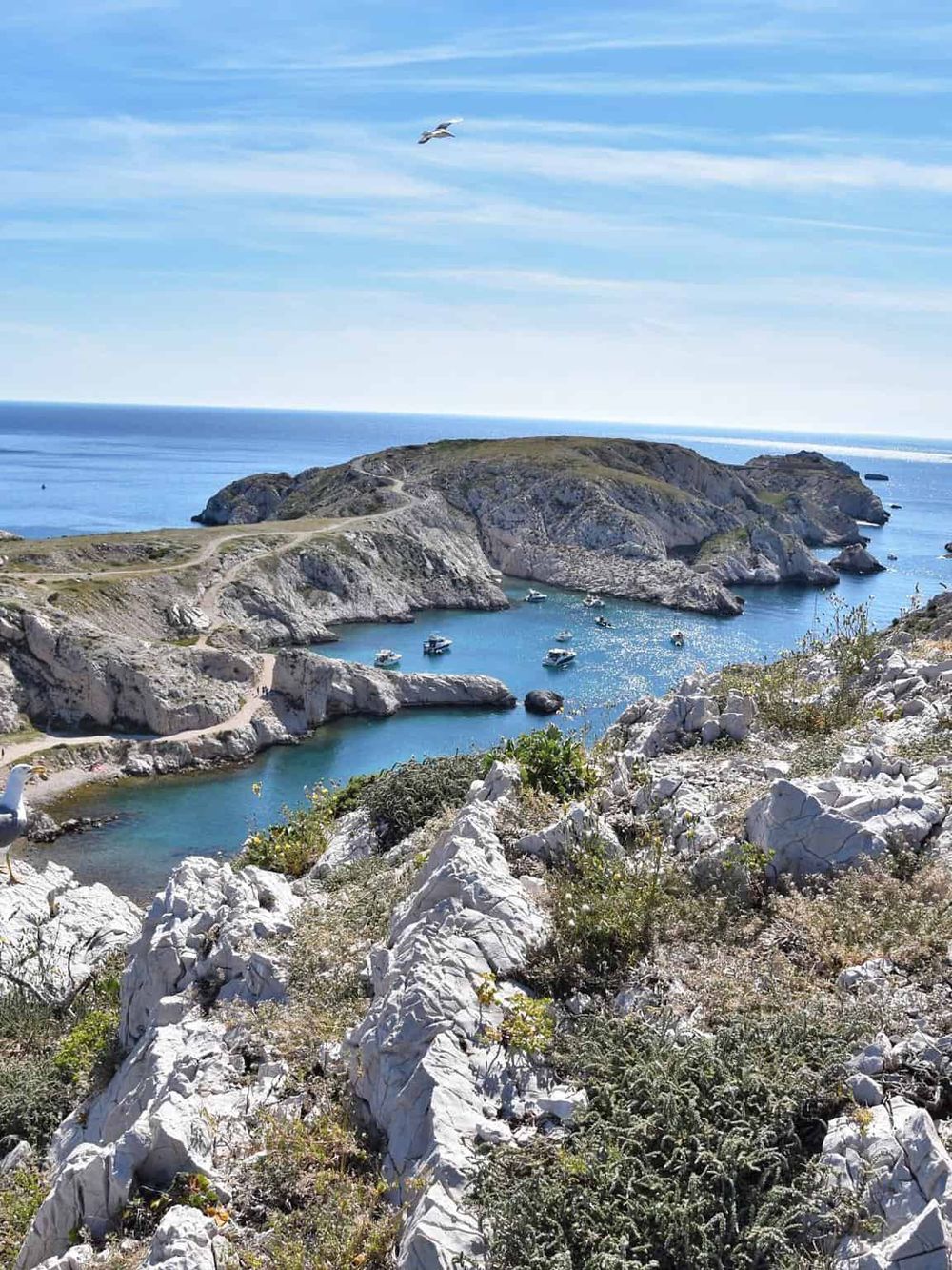 Secluded coastal bay with boats, rugged cliffs, and scenic landscape, perfect for navigation and adventure.
