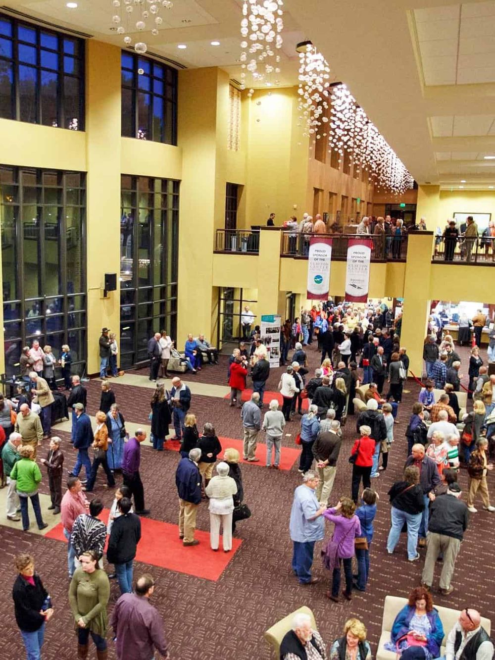 Vibrant conference center lobby with guests networking and exploring event booths.