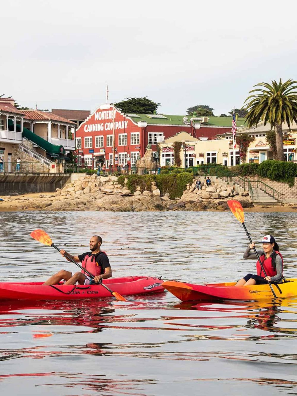 Enjoying kayaking near California's harborfront with Monterey Canning Company in the background.