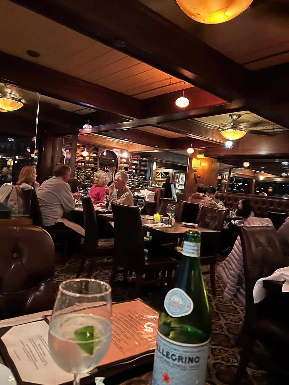 Cozy restaurant interior with warm lighting, celebrated dining atmosphere, and guests enjoying their meals.