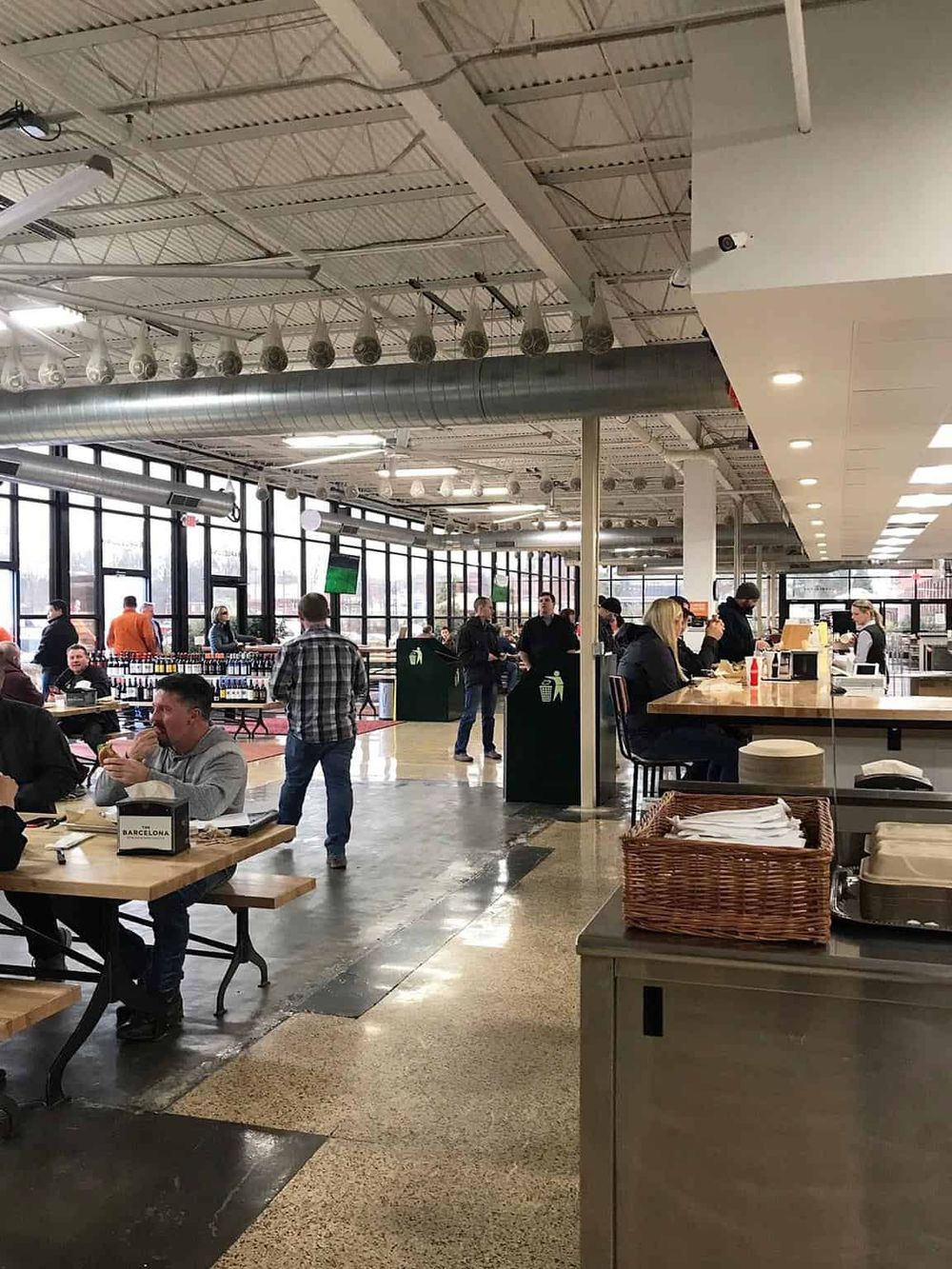 Modern airport restaurant interior with travelers dining and ordering food.