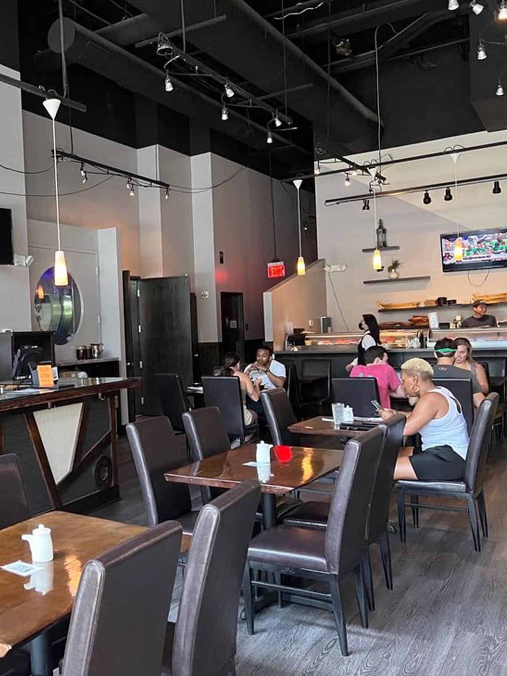 Modern restaurant interior with dining area and bar, guests enjoying meals, casual ambiance, QuestForDirections.