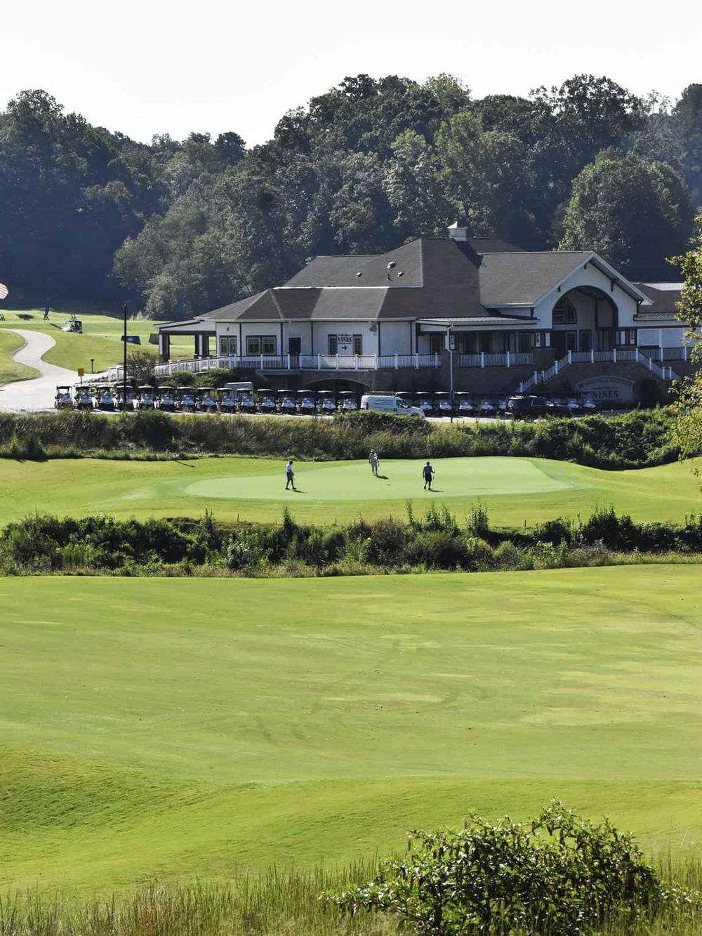 Golf course at Quest for Directions, scenic view with golf players and clubhouse.