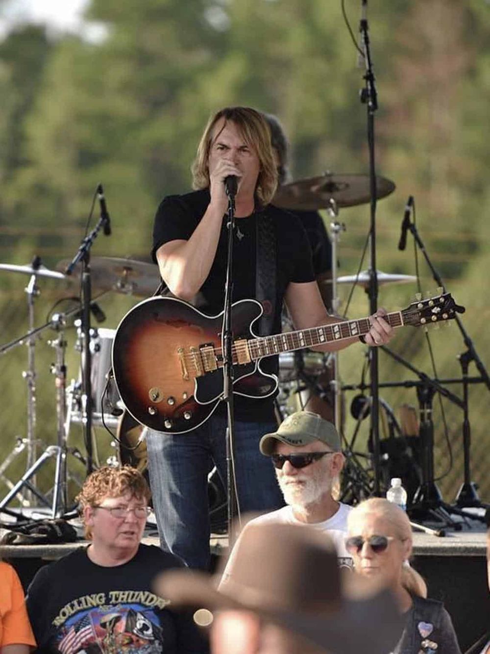 Vibrant outdoor live music performance at QuestForDirections event, showcasing talented musicians and engaging audience.