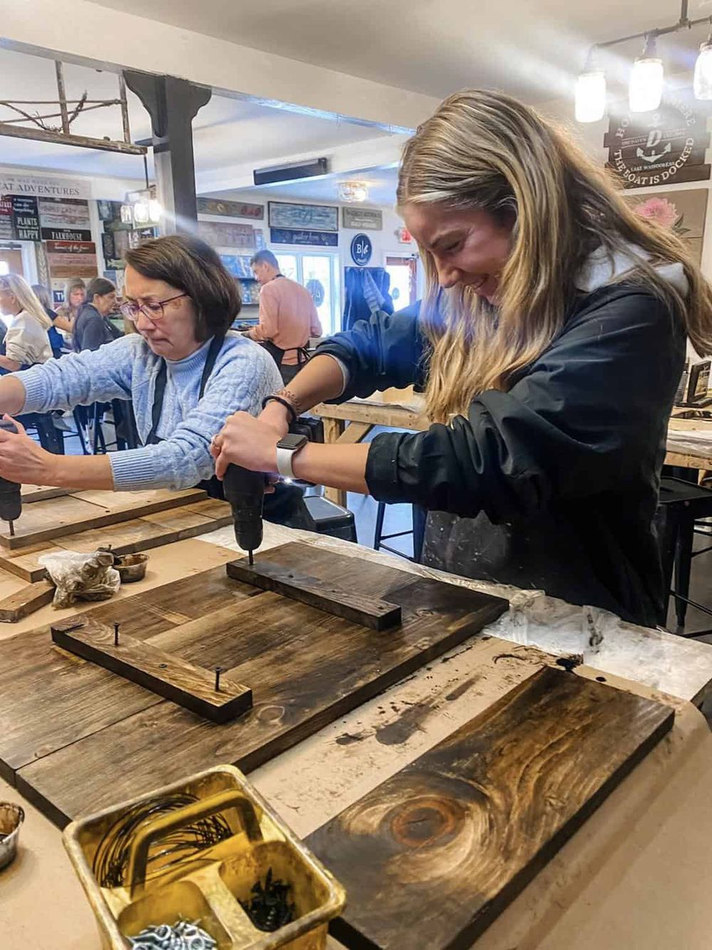 Handmade wooden signs being crafted at a workshop, showcasing craftsmanship and DIY direction signs.