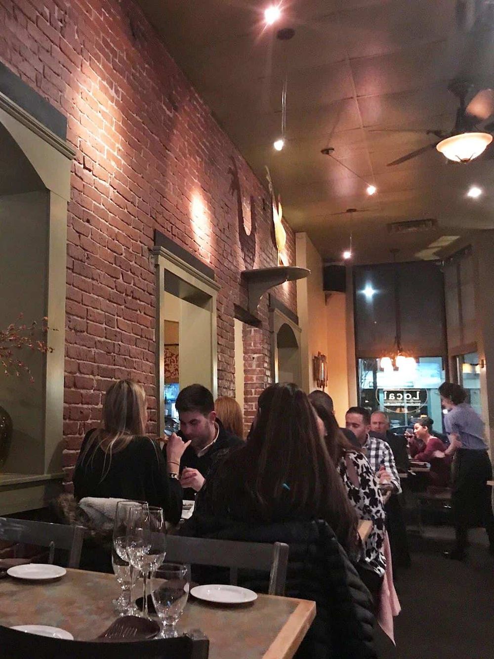 Cozy restaurant interior with exposed brick walls and ambient lighting for a memorable dining experience.