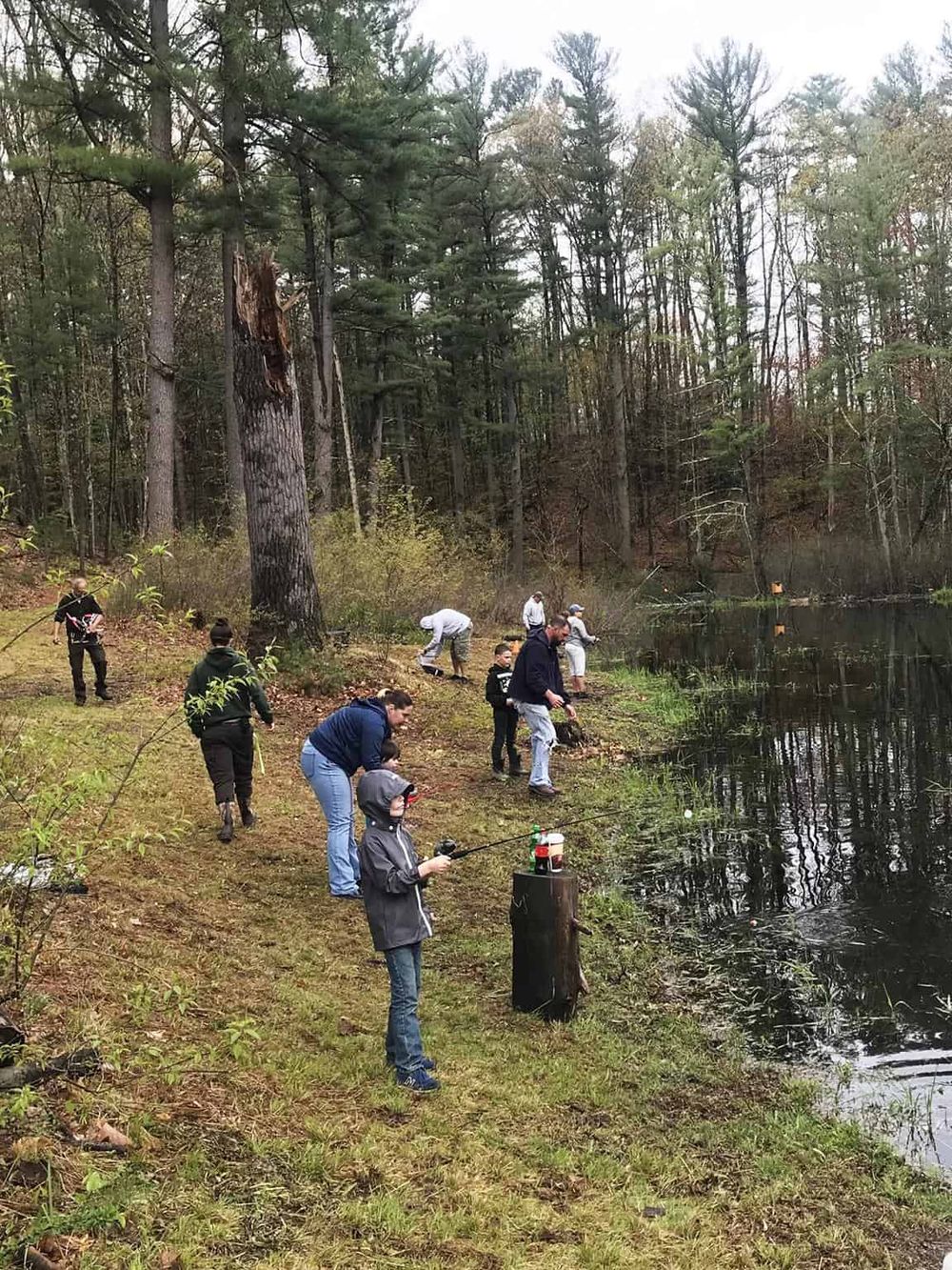 Fishing adventure at a scenic lakeside with a group of people, perfect for outdoor fishing and nature lovers.