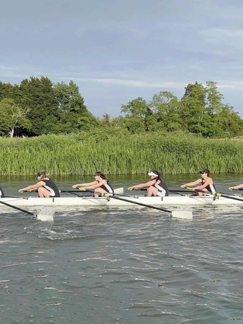1. Outdoor rowing team practicing on river with green trees, healthy water activity, athletic sports.