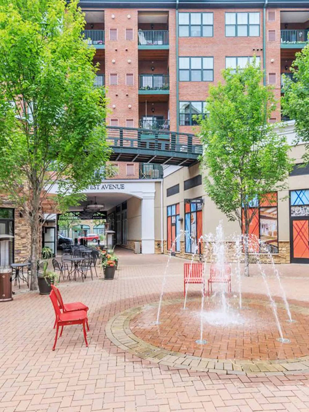 Modern residential building with outdoor fountain and seating area, urban lifestyle, and community space.