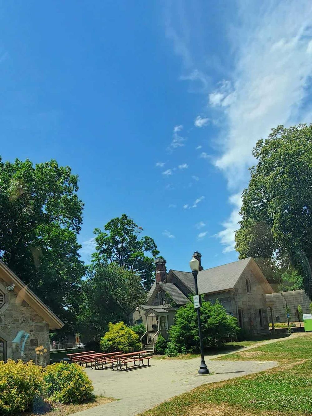 Charming historic house surrounded by greenery under clear blue sky, ideal for exploring local heritage and outdoor activities.