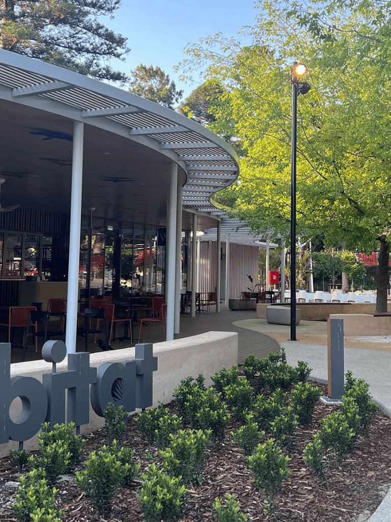 Modern outdoor dining area at QuestForDirections restaurant with lush greenery and trendy architecture.