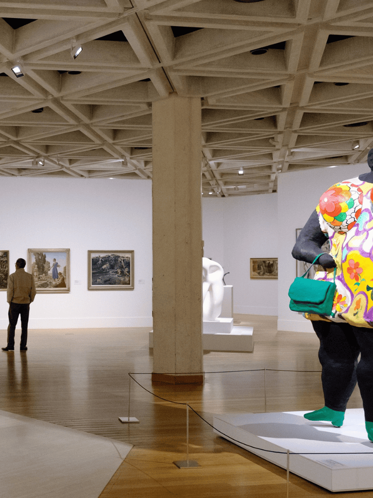 Modern art museum interior with sculptures and visitors exploring artwork, highlighting art appreciation and cultural experience.