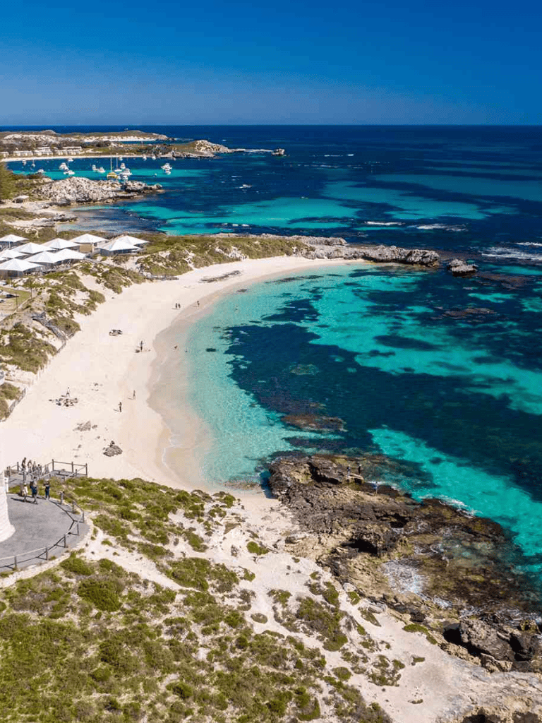 Pristine beach with turquoise waters and rocky shoreline, ideal for relaxation and water activities.