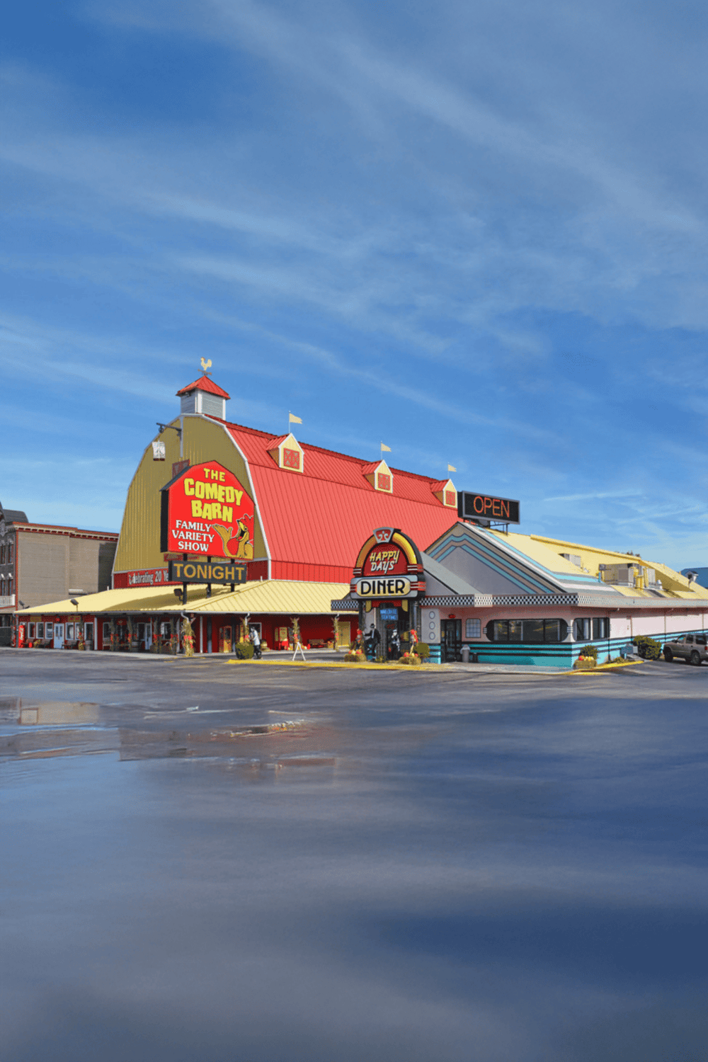 Colorful restaurant and entertainment complex with bold signage, bright colors, and a clear blue sky.