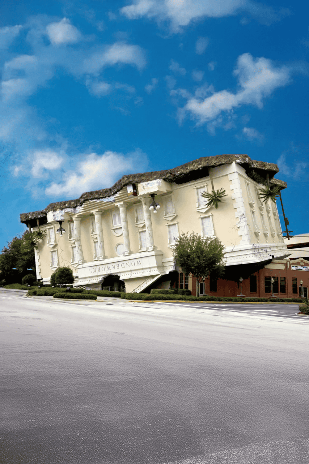 Upside-down building resembling a classical mansion with columns and the word "WONDERWORKS" on it.