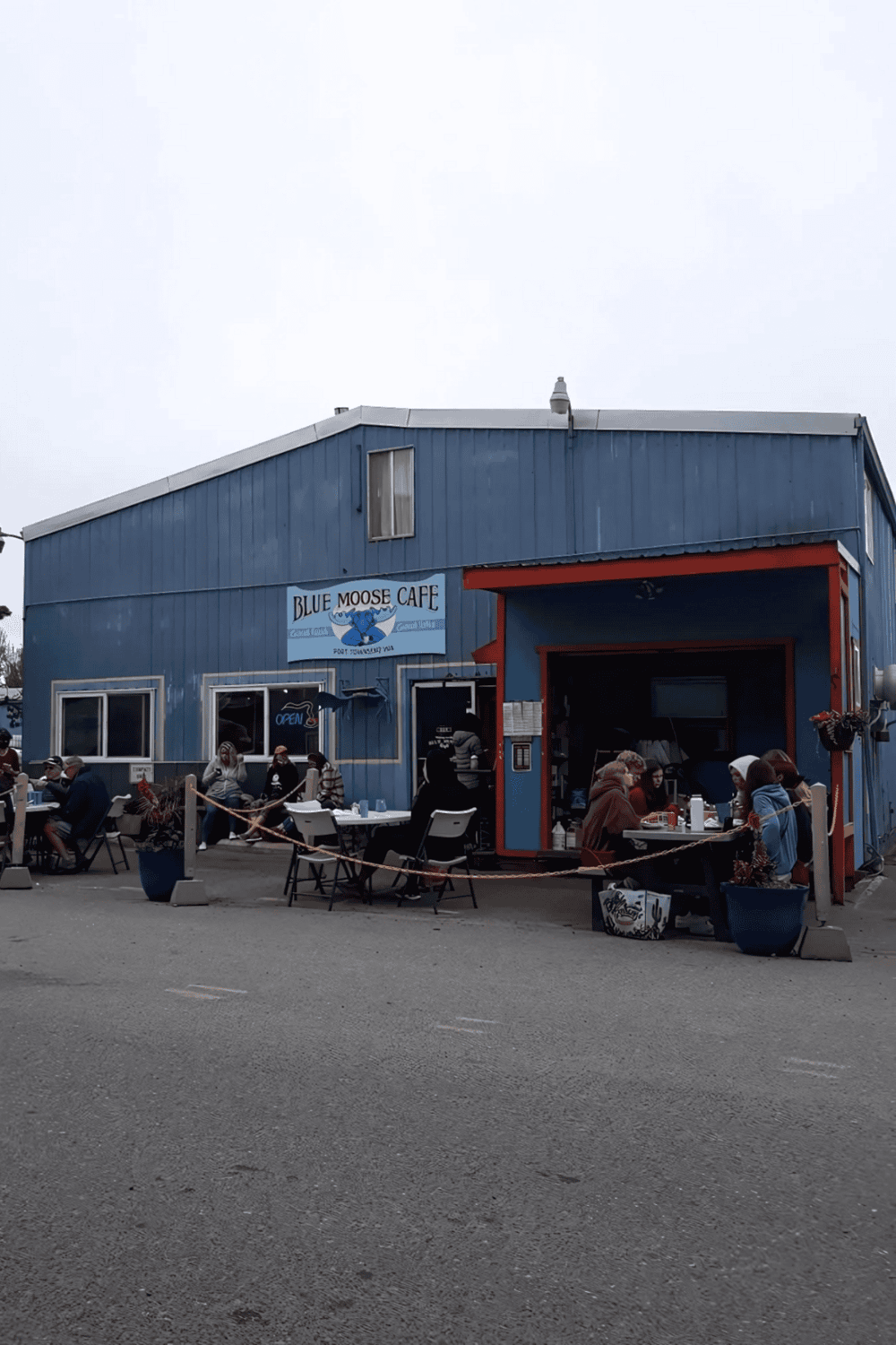 Cozy outdoor dining at Blue Moose Cafe in a charming blue building, popular spot for local food and community gatherings.