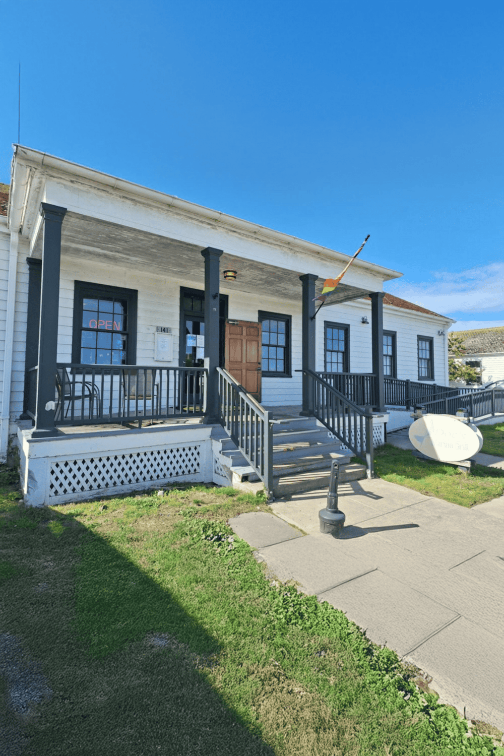 Historic white building with black accents and small porch, part of Quest for Directions.