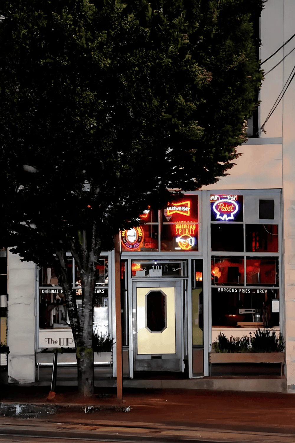 1. Neon signs of bars and restaurants outside a downtown eatery, inviting nightlife.