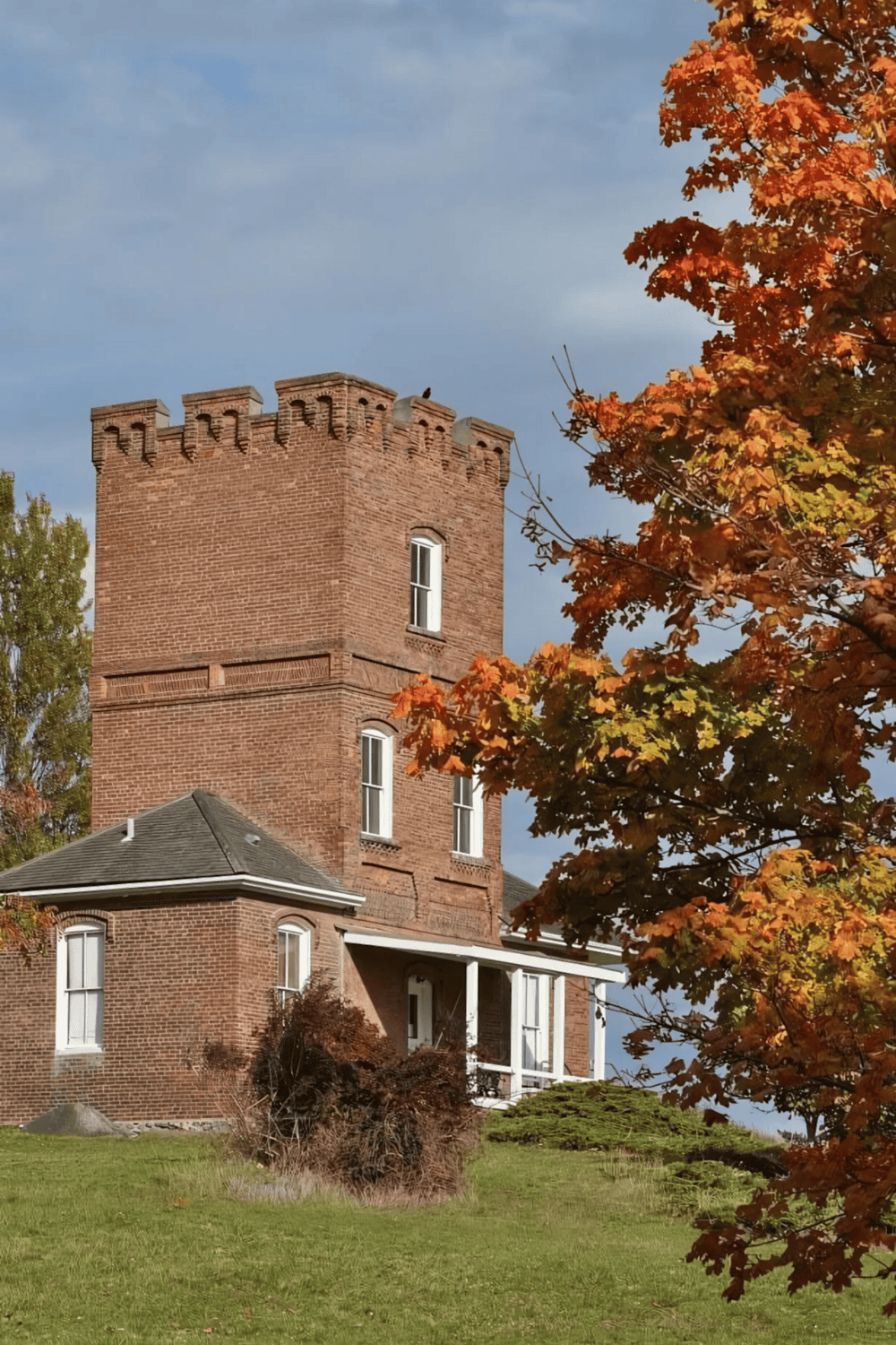 1. Historic brick tower with fall foliage and blue sky scenery.