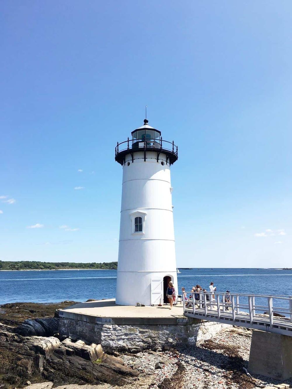 Lighthouse by the water emitting guiding light, popular scenic destination for visitors.