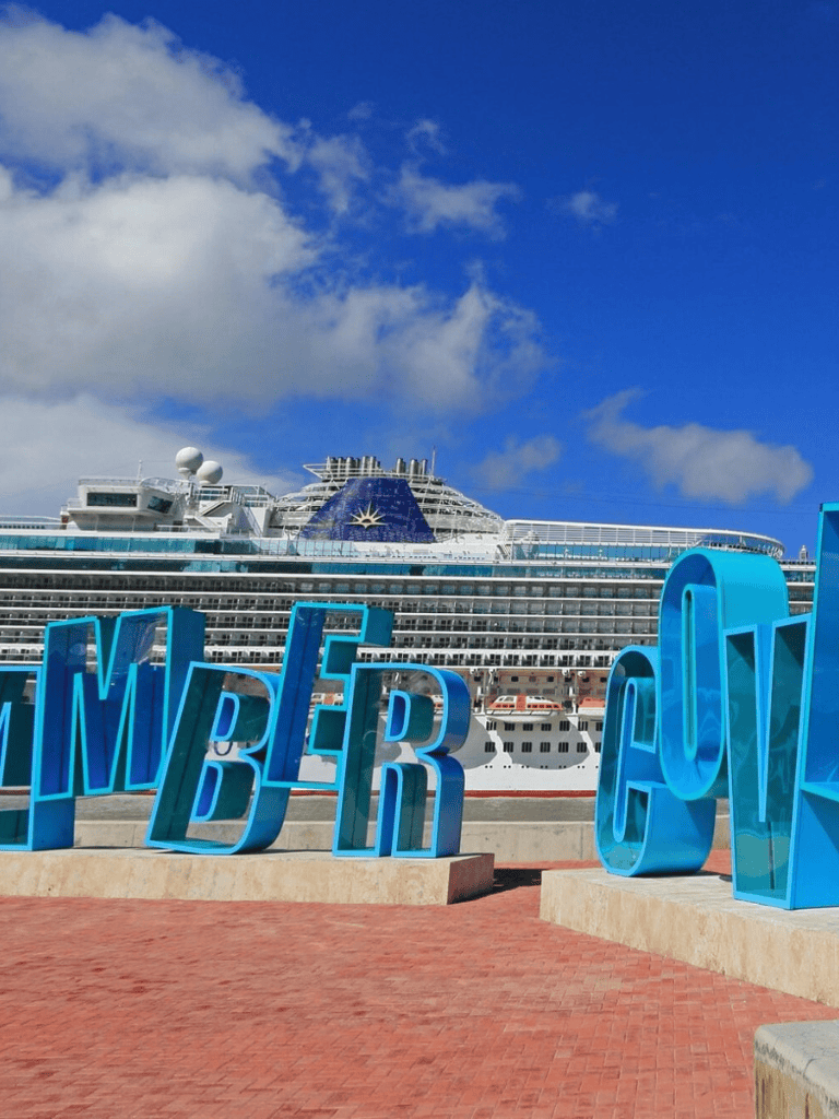 Cruise ship docked at port in Miami, Florida, with Quest for Directions signage in foreground.