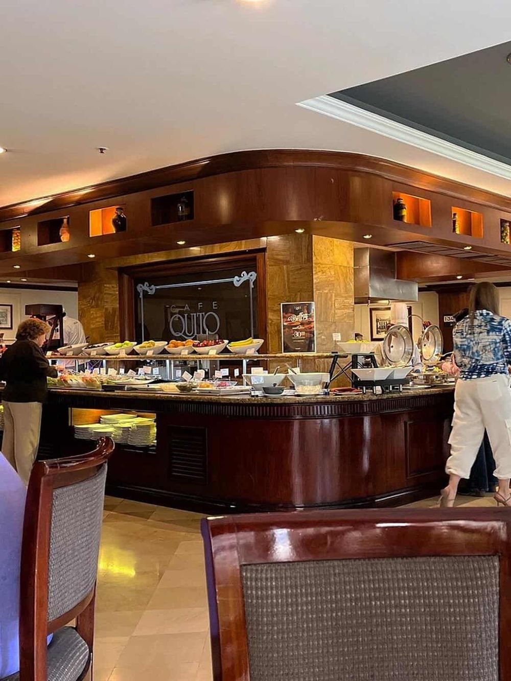 Elegant hotel buffet with diverse food options and warm wood decor, ideal for travel dining.