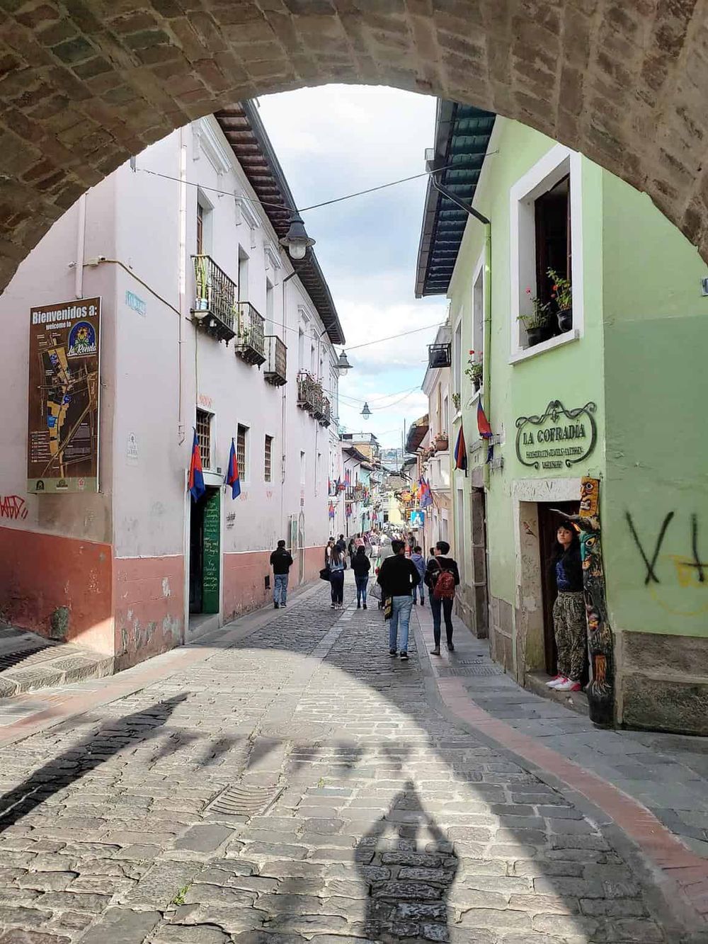 Colorful street scene in Antigua Guatemala, featuring vibrant buildings, cobblestone streets, and local pedestrians.