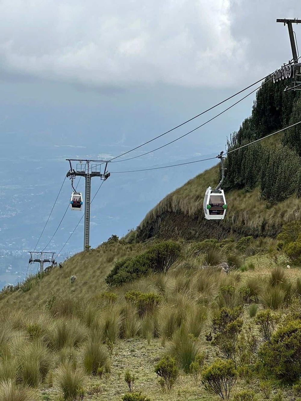 Cable car on mountain hillside with scenic view, outdoor adventure travel, and transport.