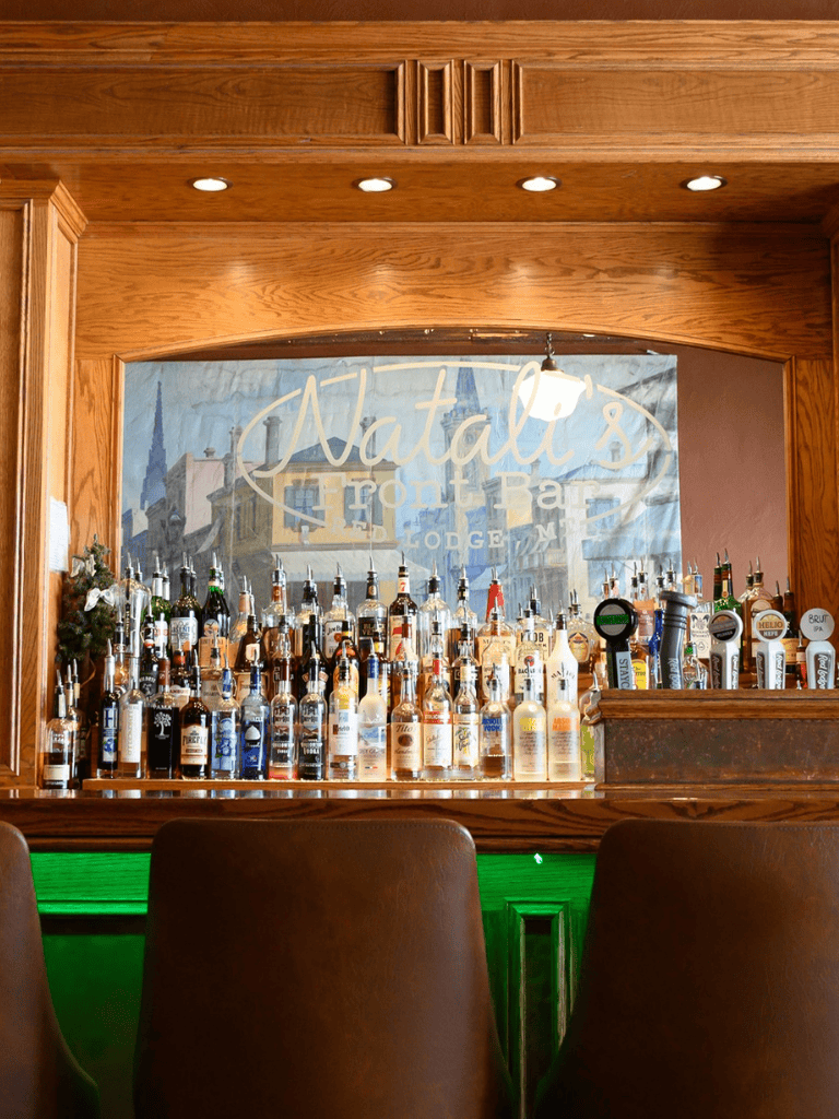 Craft bar at Natalie’s Front Bar Lodge with liquor bottles on display.