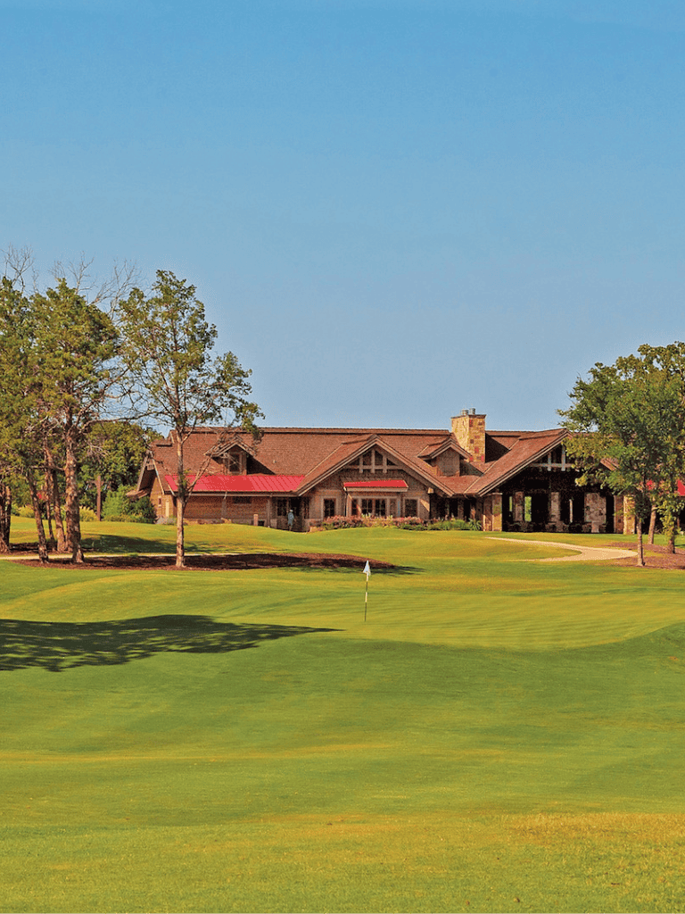Serene golf course with clubhouse in the background, ideal for outdoor recreation and sports.