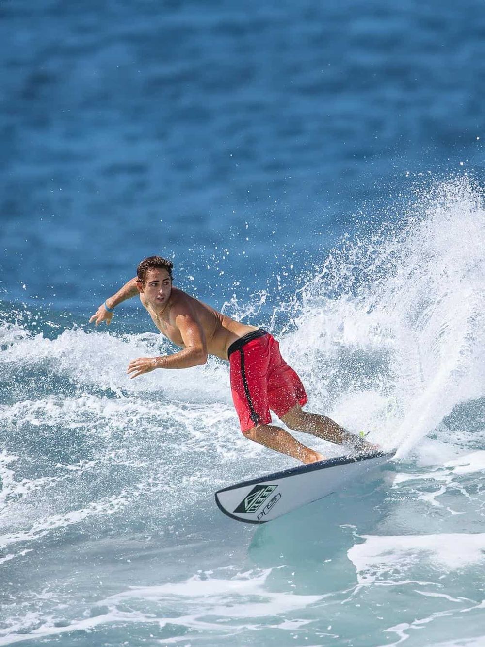 Vibrant young boy surfing on ocean waves at the beach, enjoying fun water activities.