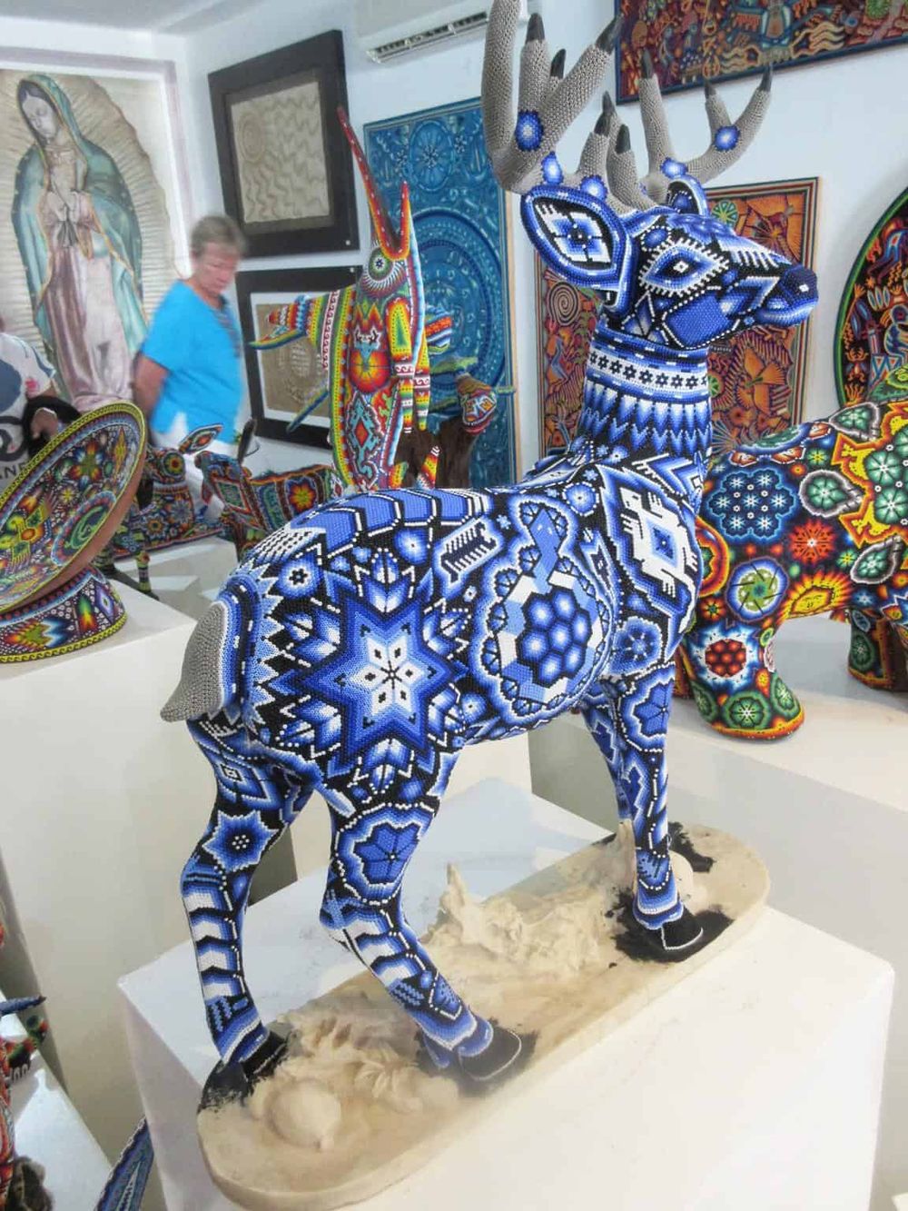 Colorful beaded sculpture of a deer, part of accessible indigenous art collection, vibrant cultural exhibit in gallery.