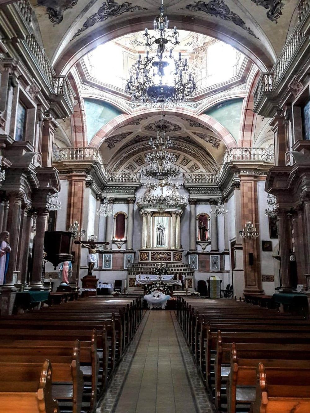 Elegant church interior featuring ornate architecture, chandeliers, and religious statues, perfect for spiritual reflections and ceremonies.