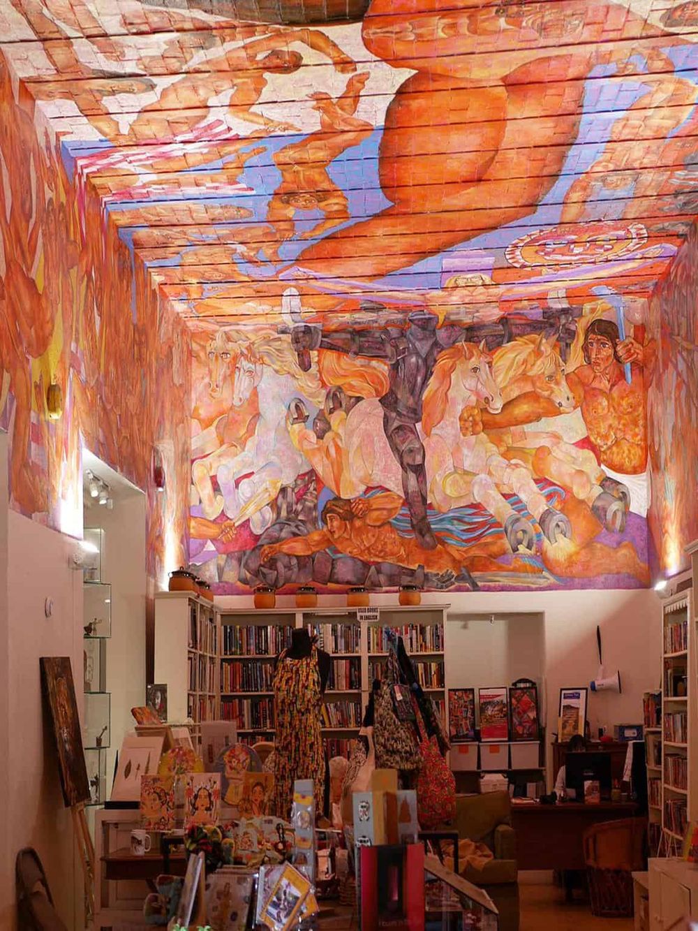 Vibrant mural artwork of horses and riders in a bookstore interior, showcasing colorful, artistic wall decor.