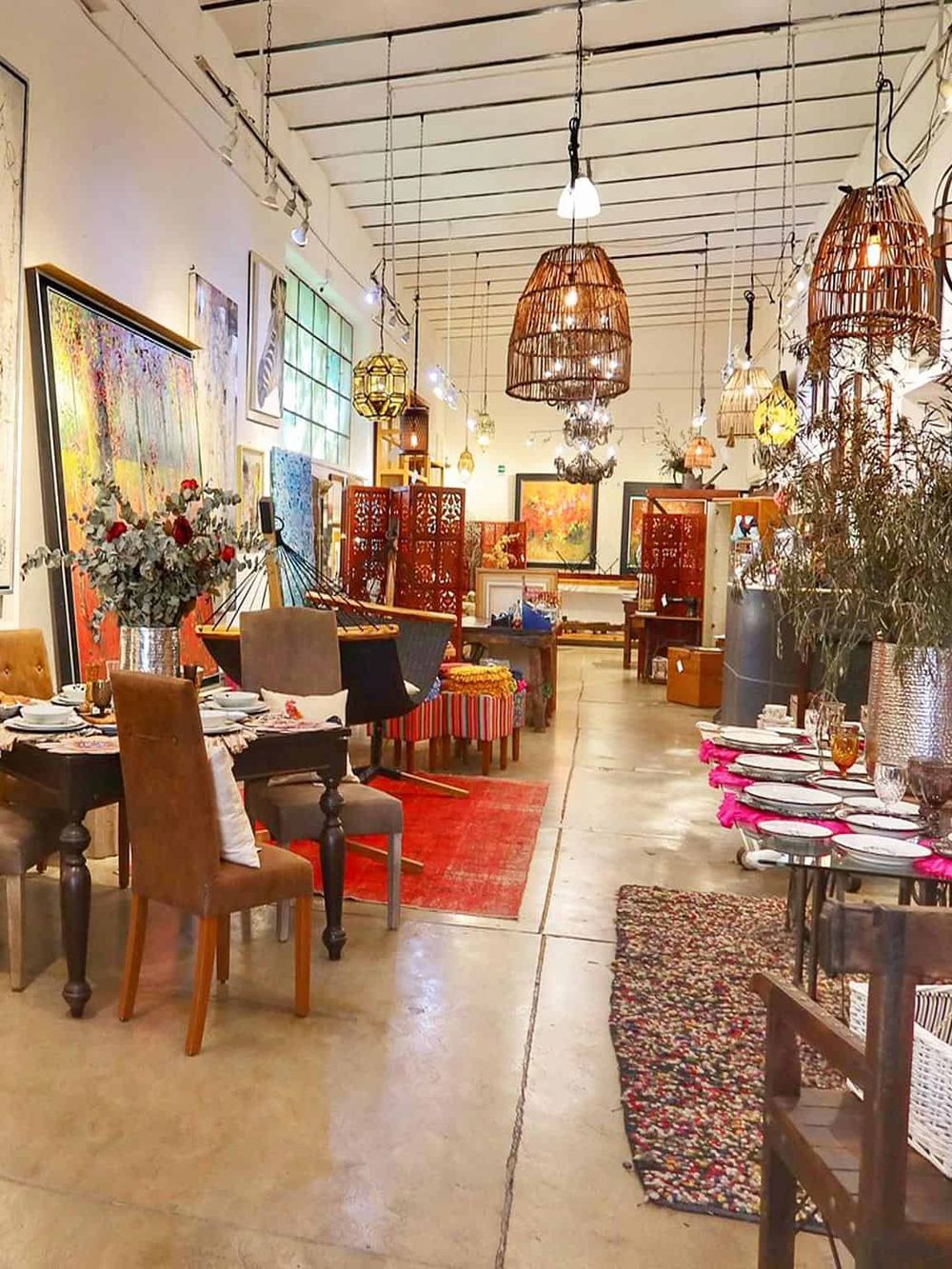Colorful interior of an art gallery restaurant with vibrant paintings, eclectic decor, and elegant table settings.
