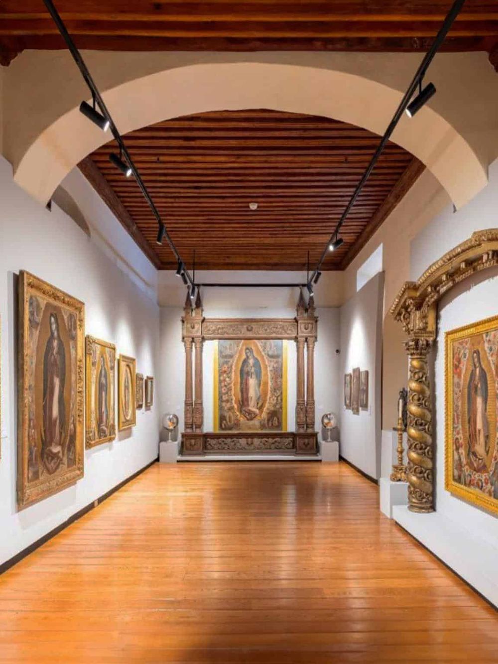 Ornate art gallery with religious paintings and wooden ceiling at QuestForDirections museum.