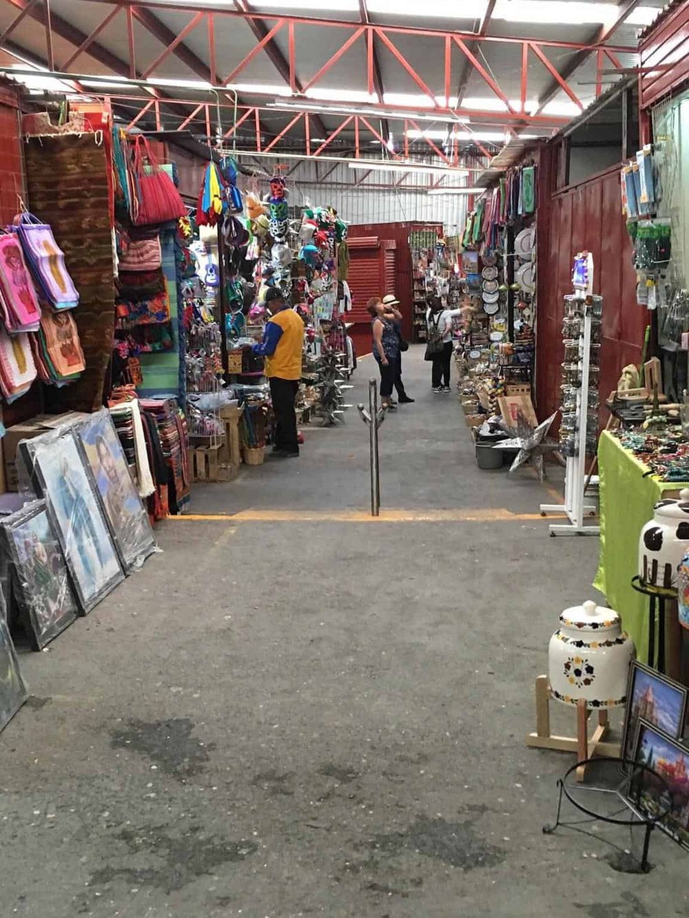 Colorful market stall with bags, artwork, and souvenirs for sale at QuestForDirections.