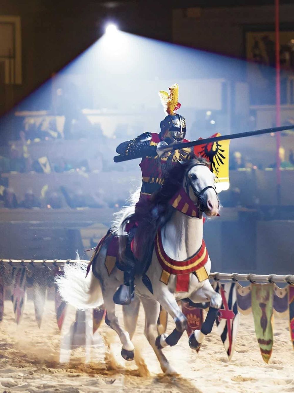 Knight jousting tournament with knight in armor on a white horse, medieval sport, and entertainment.