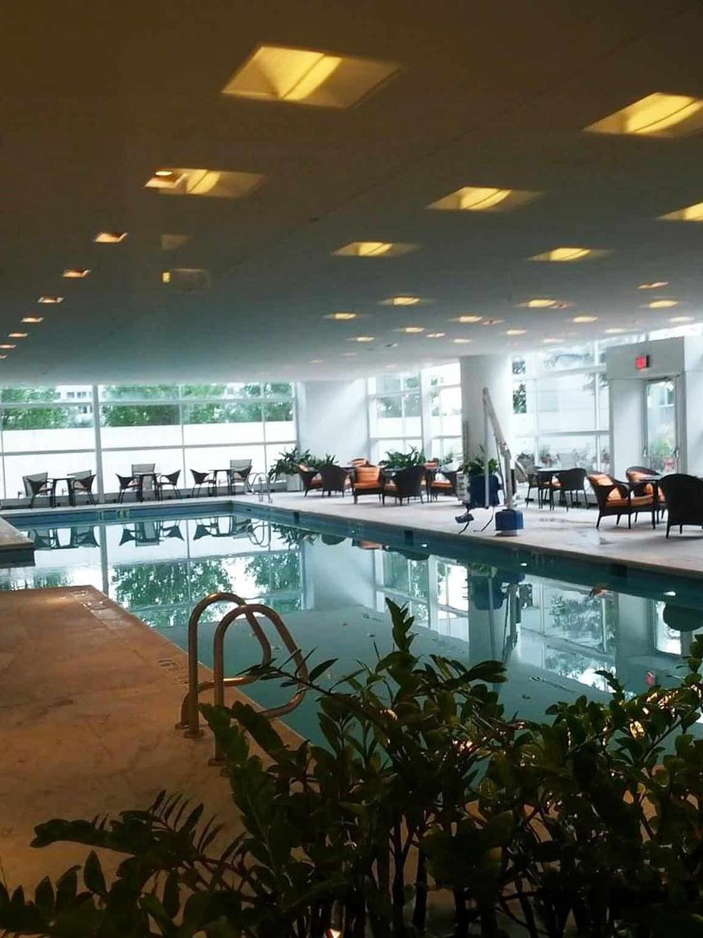Quiet indoor swimming pool at QuestForDirections hotel with lounge seating and large windows.