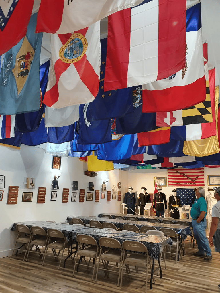 Colorful flags hanging from the ceiling in a historic museum exhibit.