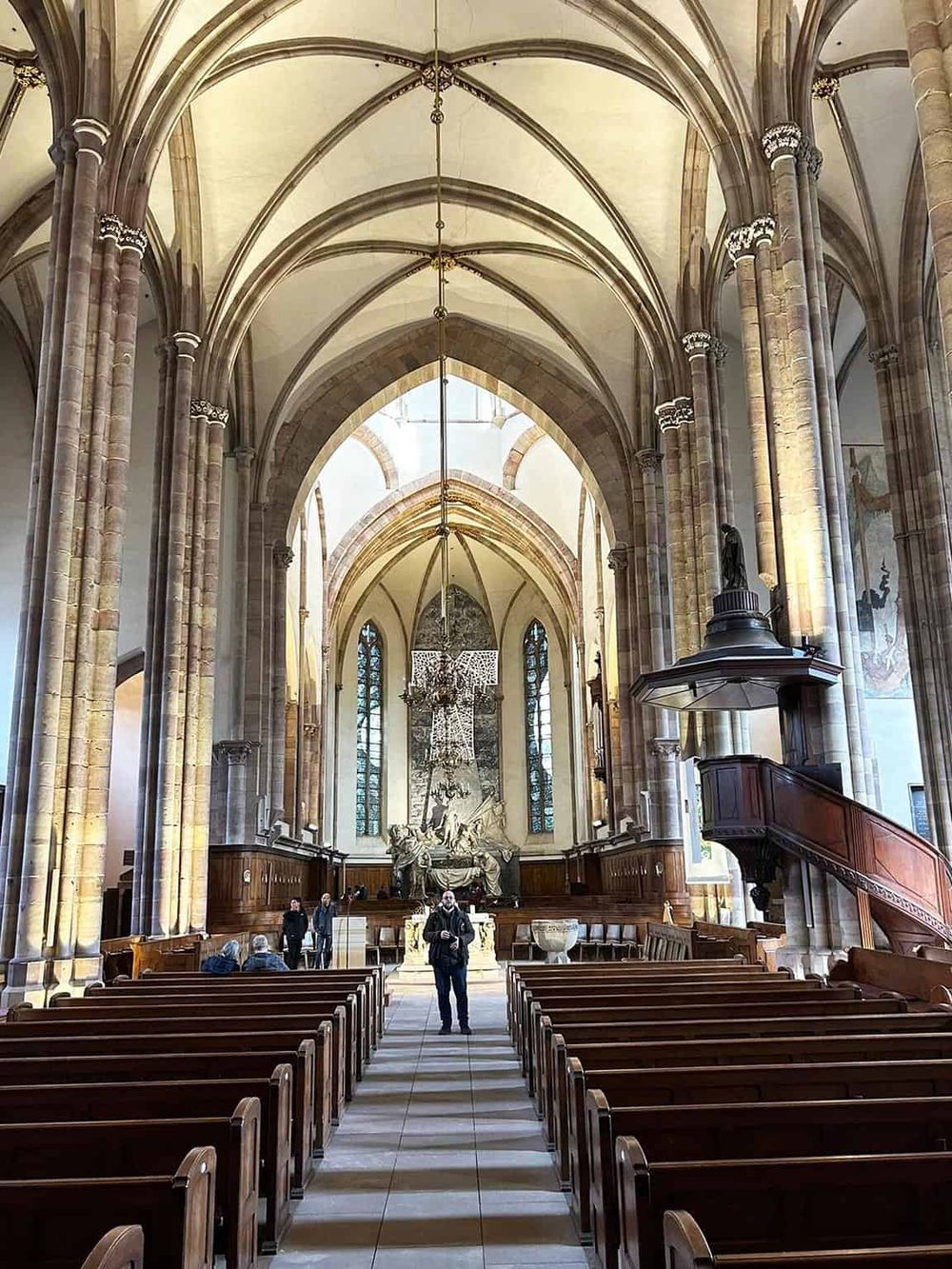 Majestic Gothic cathedral interior with tall arches and intricate architecture, a perfect destination for spiritual travel and cultural exploration.