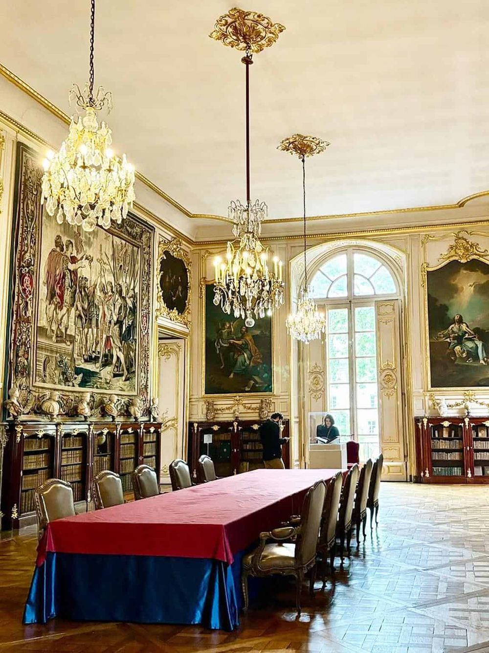 Luxurious historic library with grand chandeliers, ornate decor, and classic paintings for elegant research and reading.