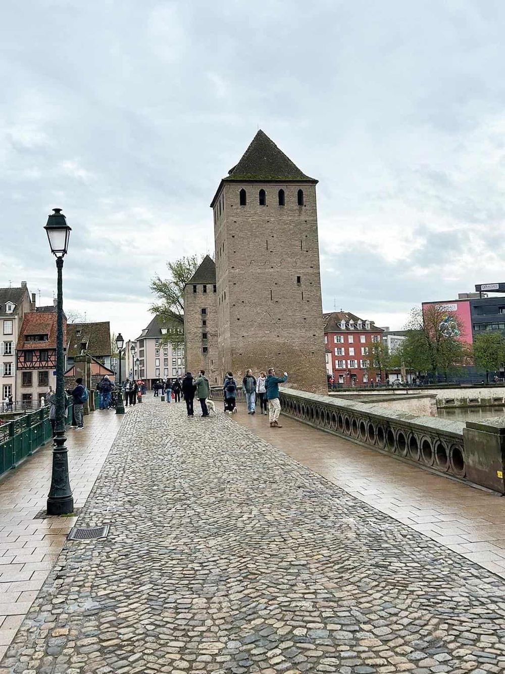 Medieval city gate and bridge over the river in Strasbourg, France, showcasing historic architecture and tourist attractions.