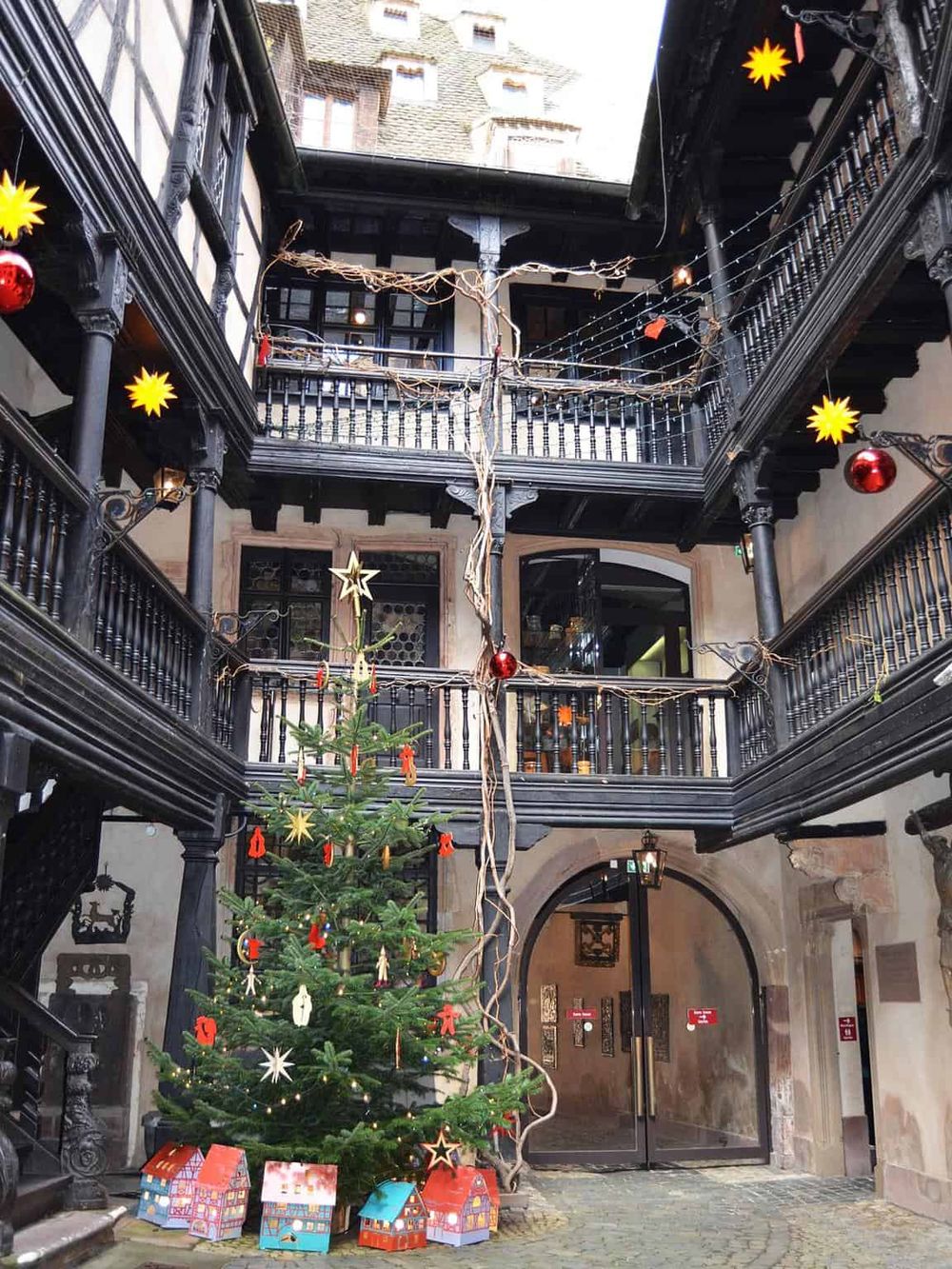 Festive hotel courtyard decorated with Christmas ornaments and a small decorated tree.