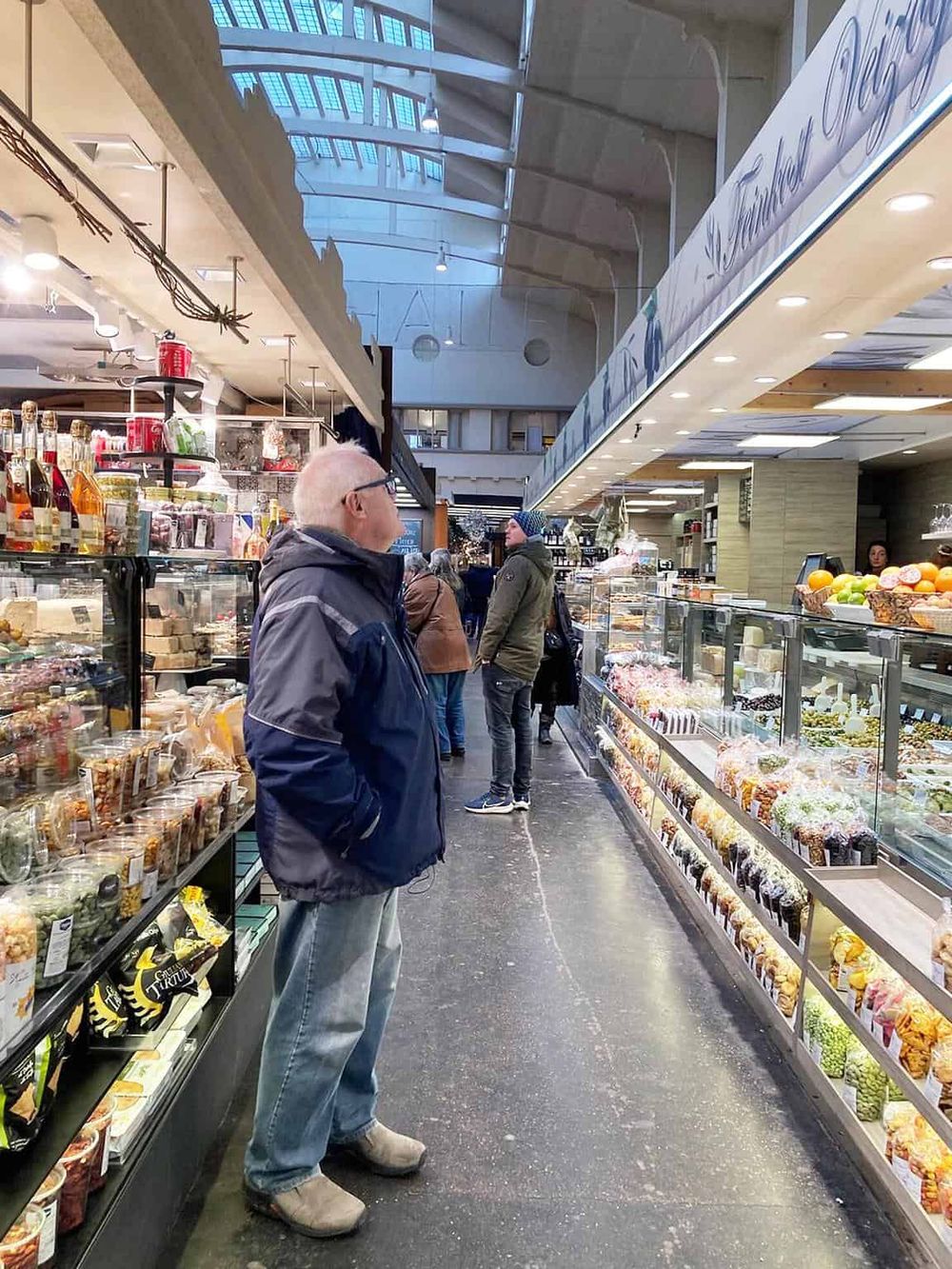 Colorful indoor marketplace with shoppers exploring artisanal food and specialty products.