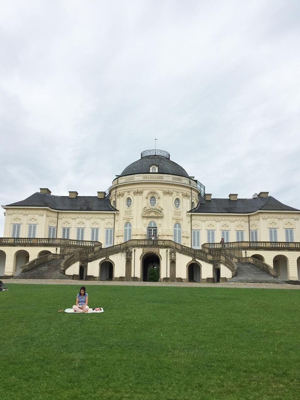 Historic palace with grand stairs and lush green lawn in the foreground, offering picturesque sightseeing opportunities.